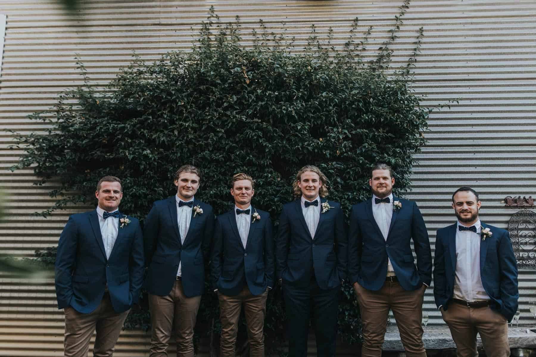 groomsmen in navy jackets and tan chinos
