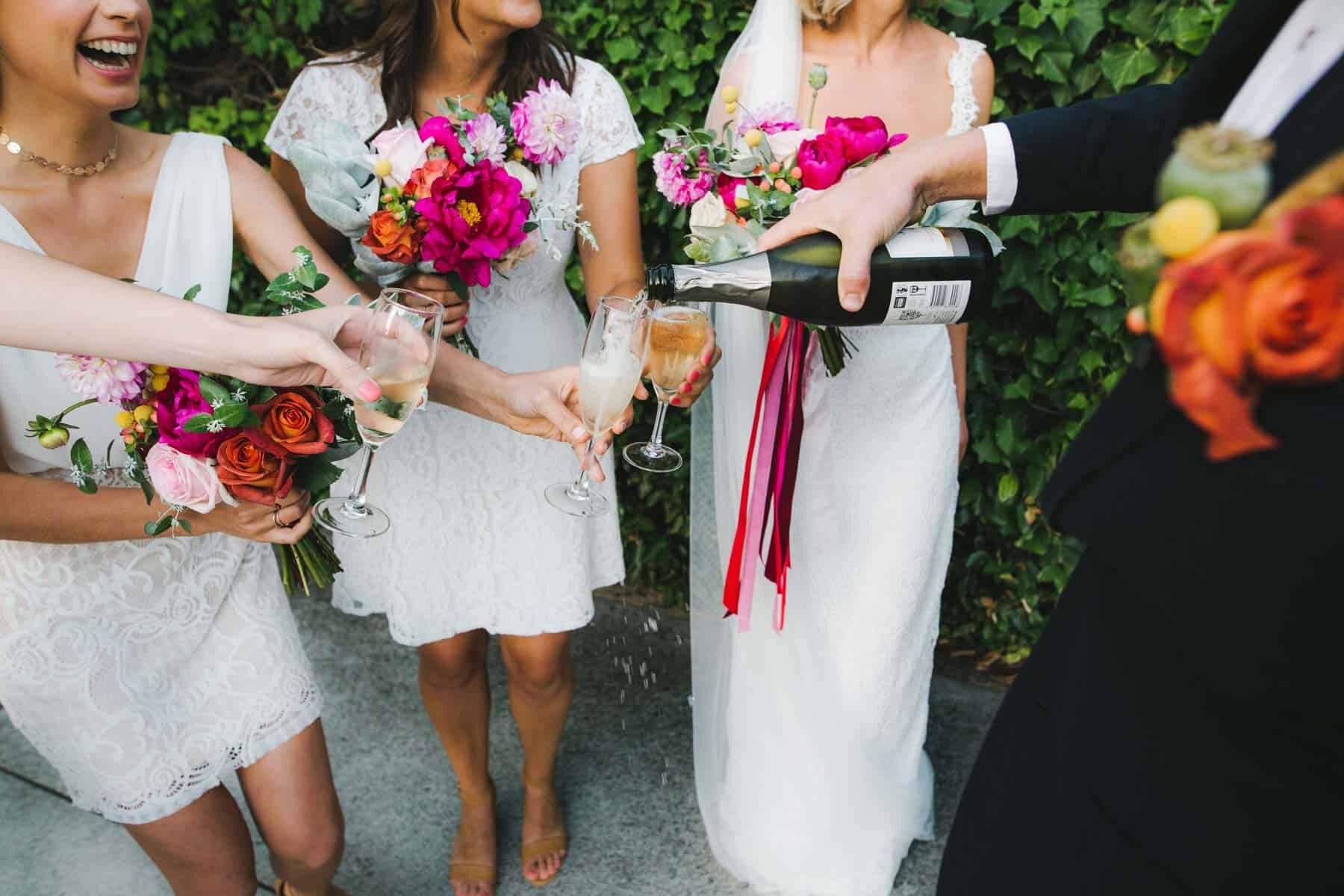 bridesmaids in white dresses with colourufl bouquets