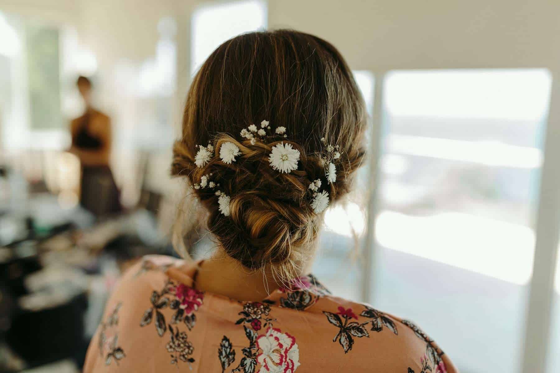 Modern upstyle wedding hair in bun with flowers