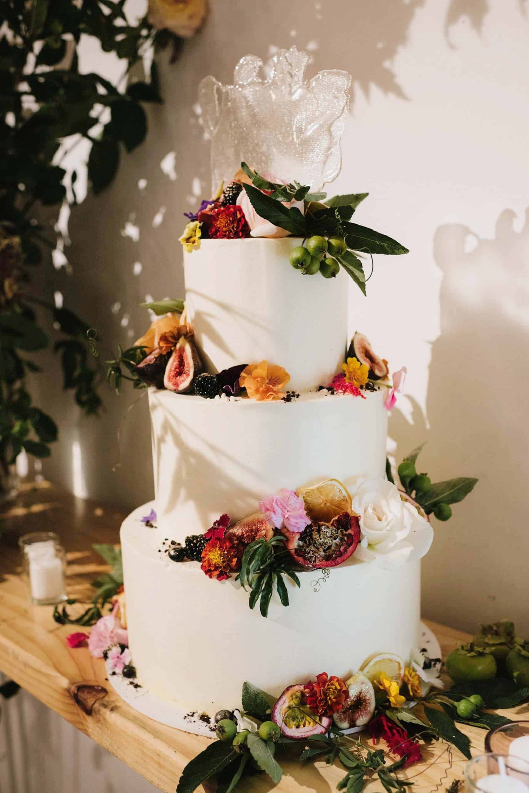 simple three tier wedding cake with fresh fruit and flowers