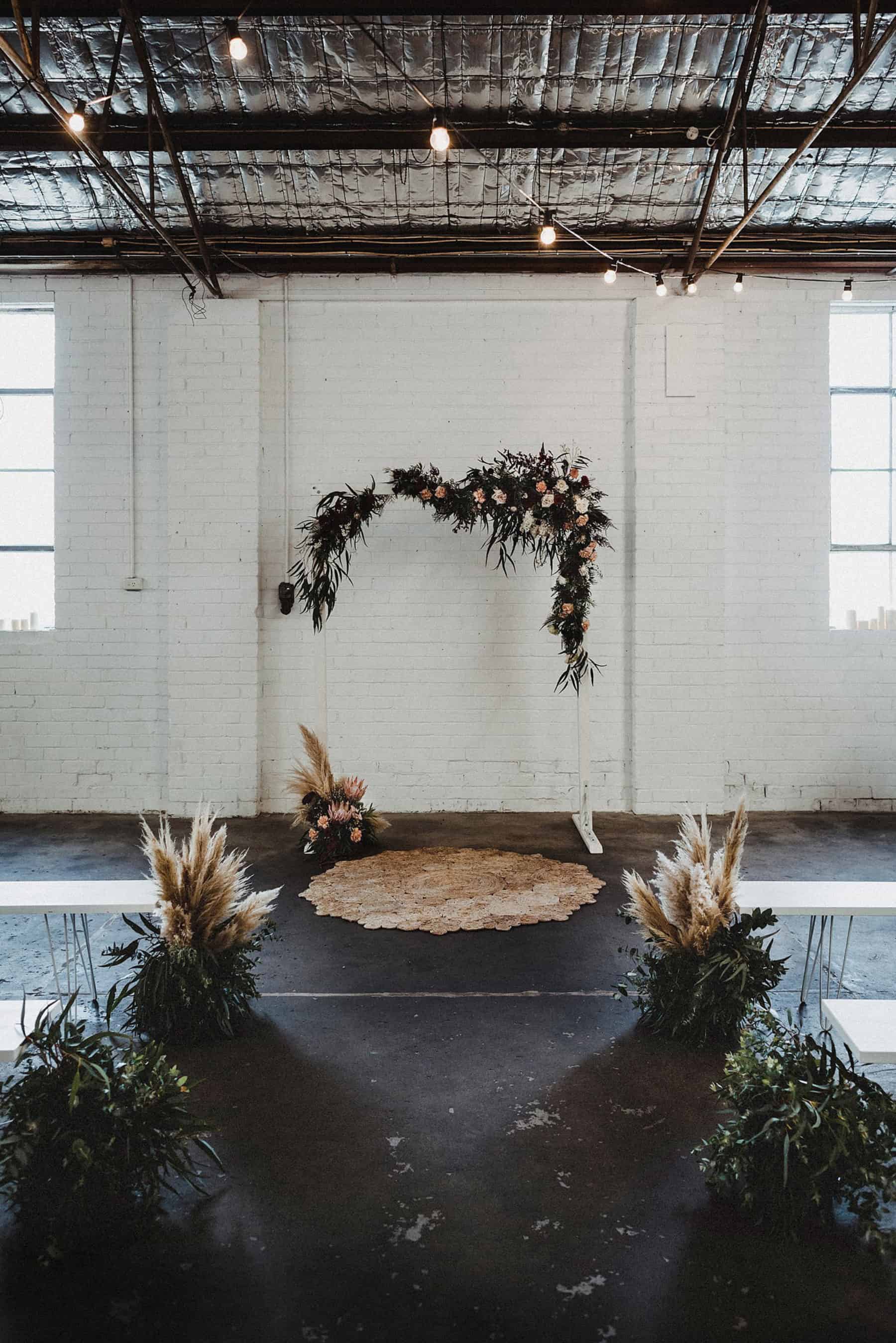 warehouse wedding with floral arch backdrop