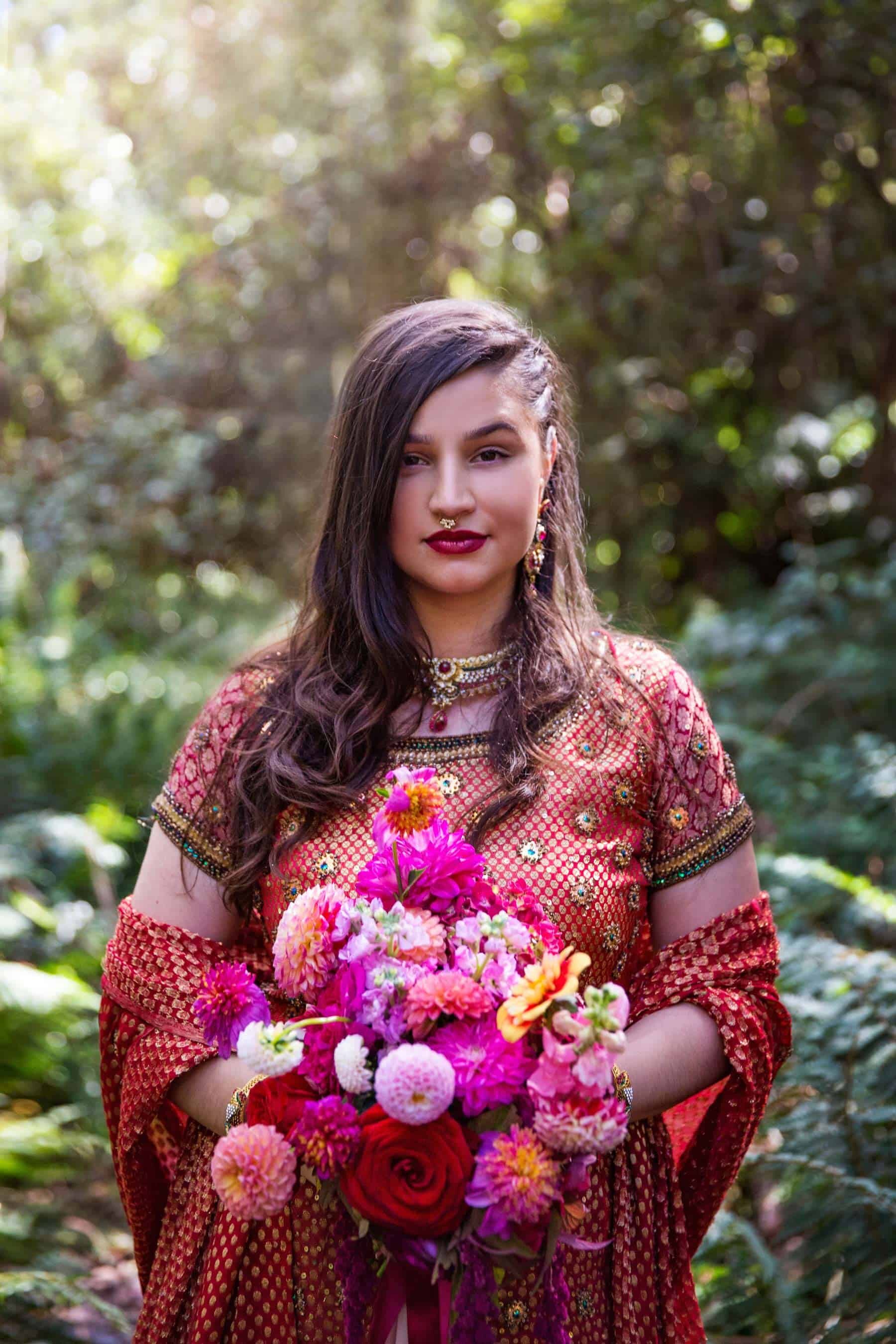 boho bride in red sari with colourful bouquet