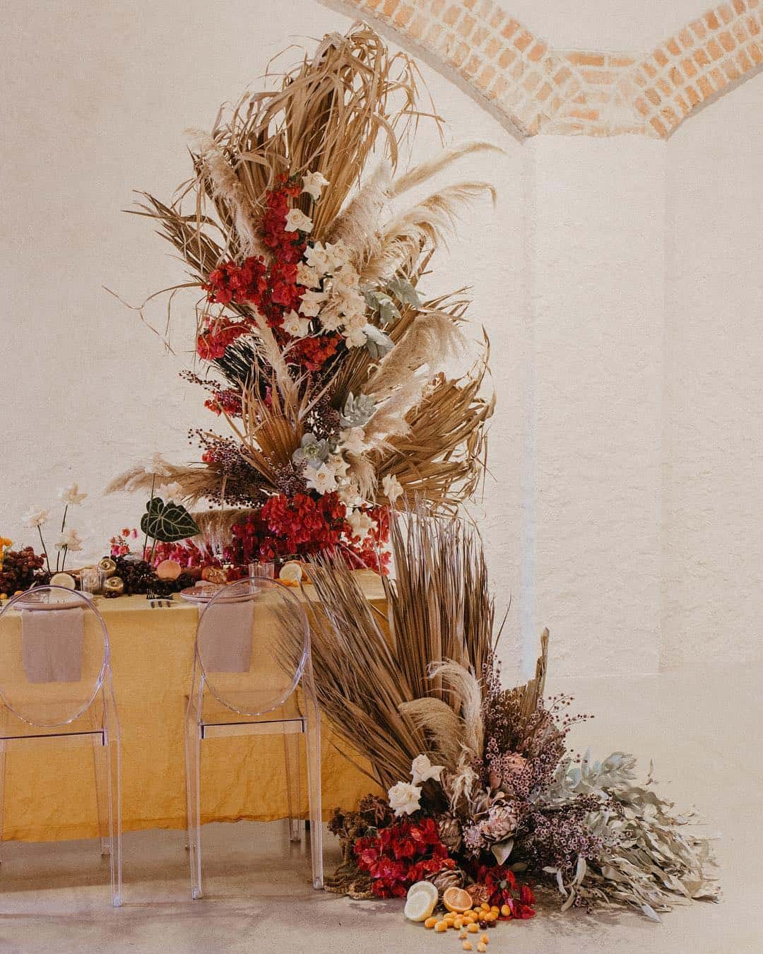 dramatic floral installation featuring dried palm leaves