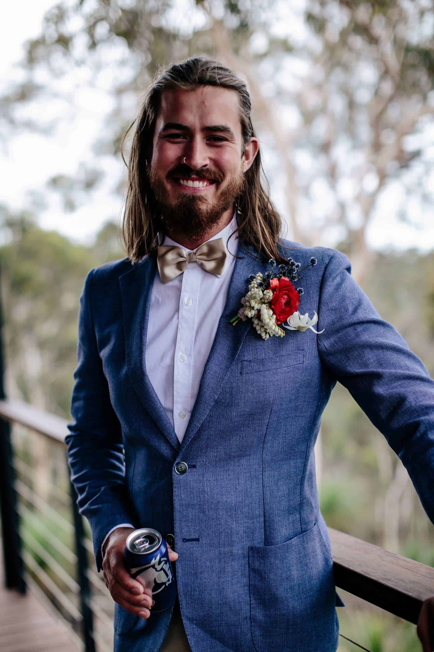 Navy blazer with gold bowtie and red rose boutonnière