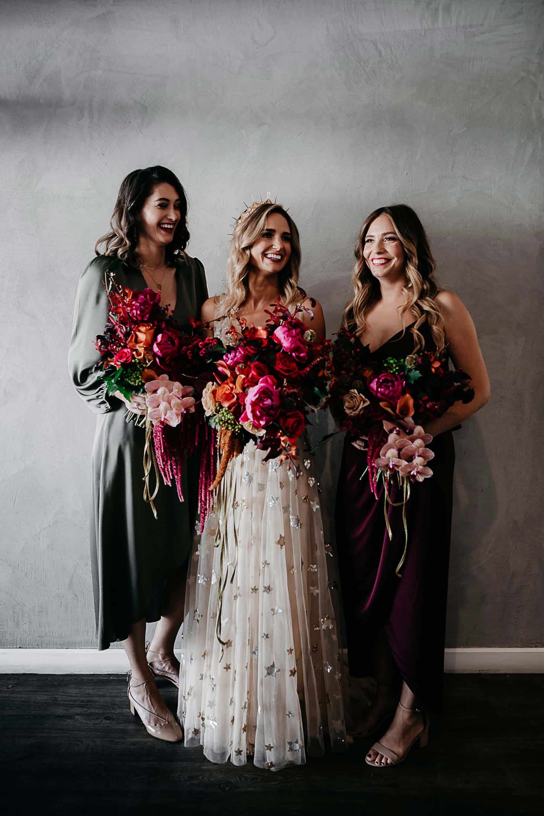 Mismatched bridesmaids wear shona joy with vibrant unstructured pink bouquets