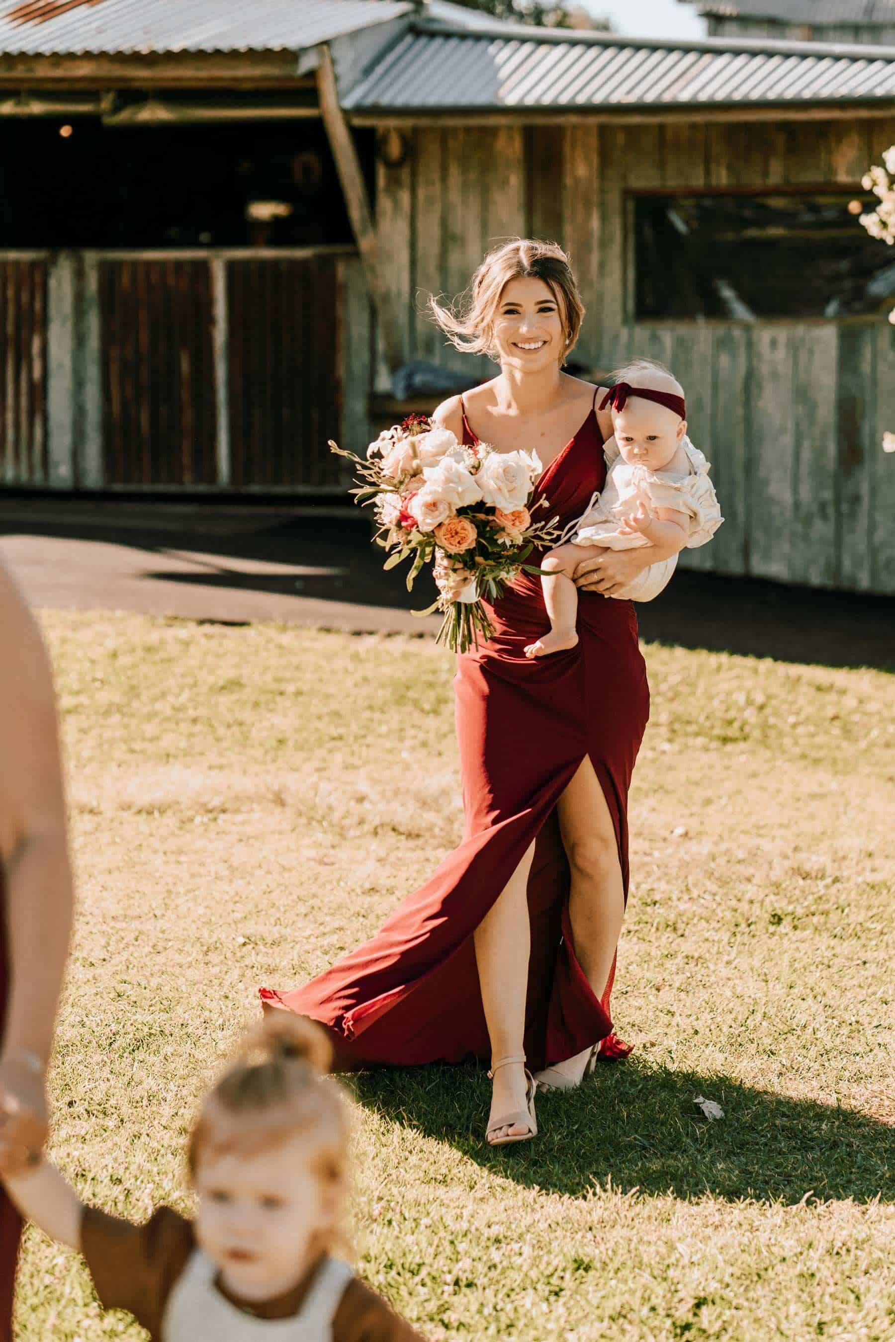 bridesmaid carrying baby down the aisle