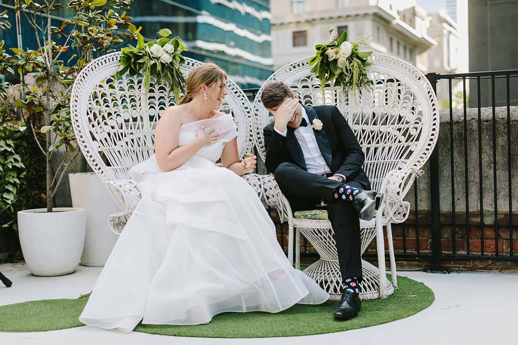 bride and groom in white peacock chairs