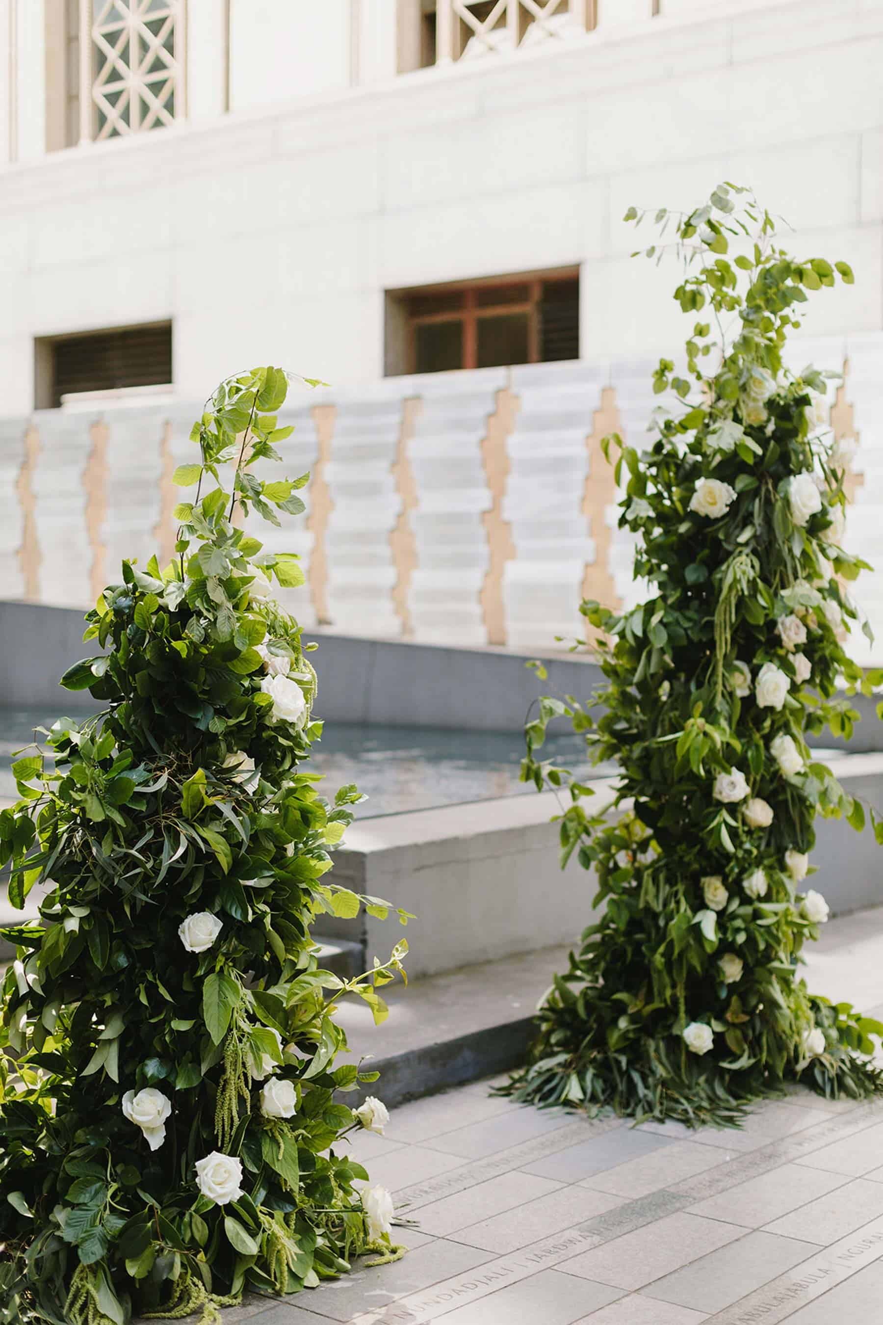 green and white floral pillars wedding backdrop