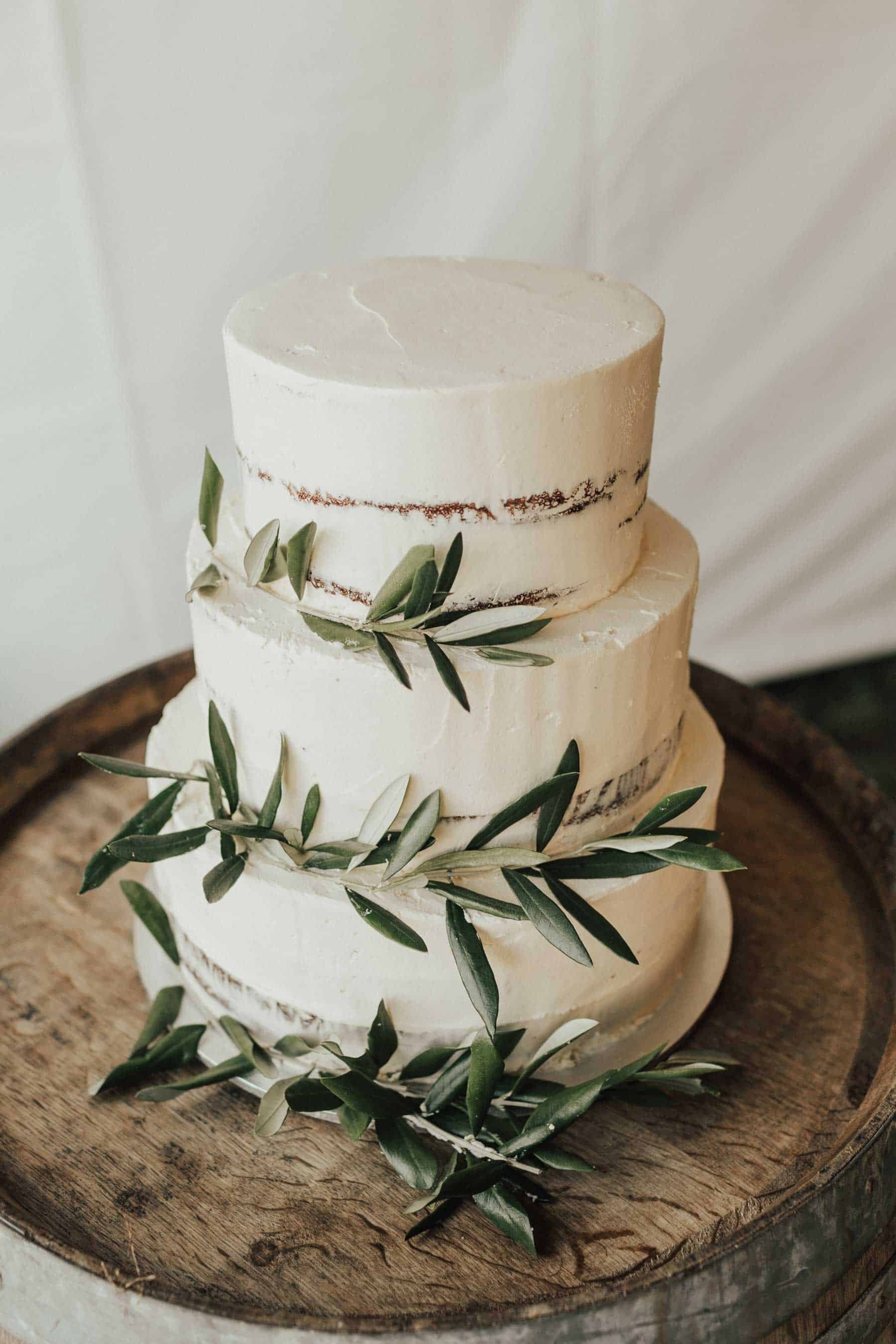 simple white wedding cake with olive leaves