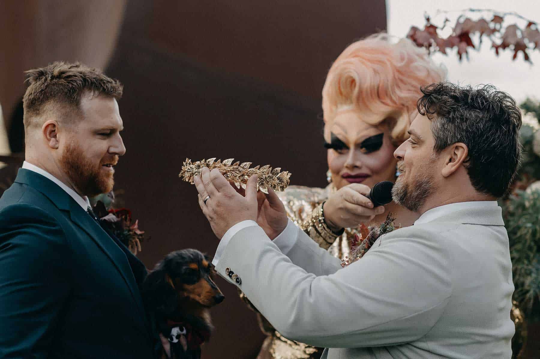 two grooms exchanging crowns instead of wedding rings
