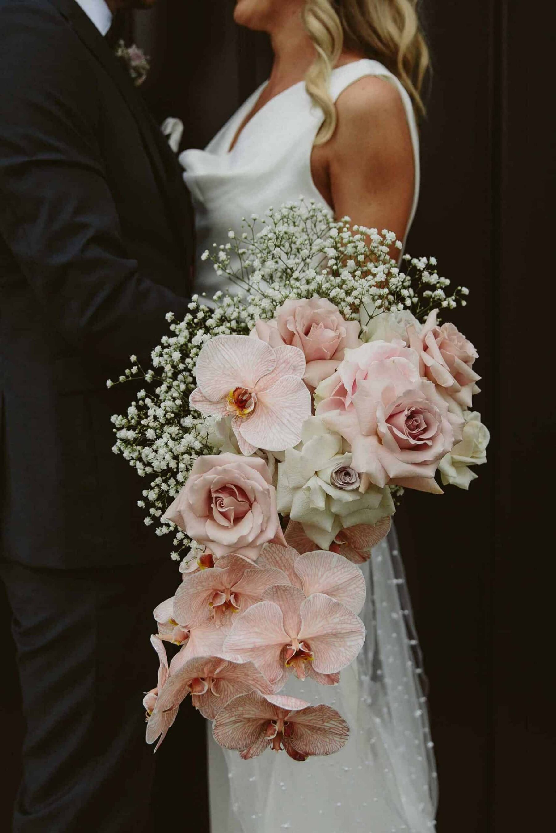 cascading blush bridal bouquet with orchids and quicksand roses